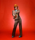 David Bowie holding a saxophone in London, 1973 — color photograph by Mick Rock.