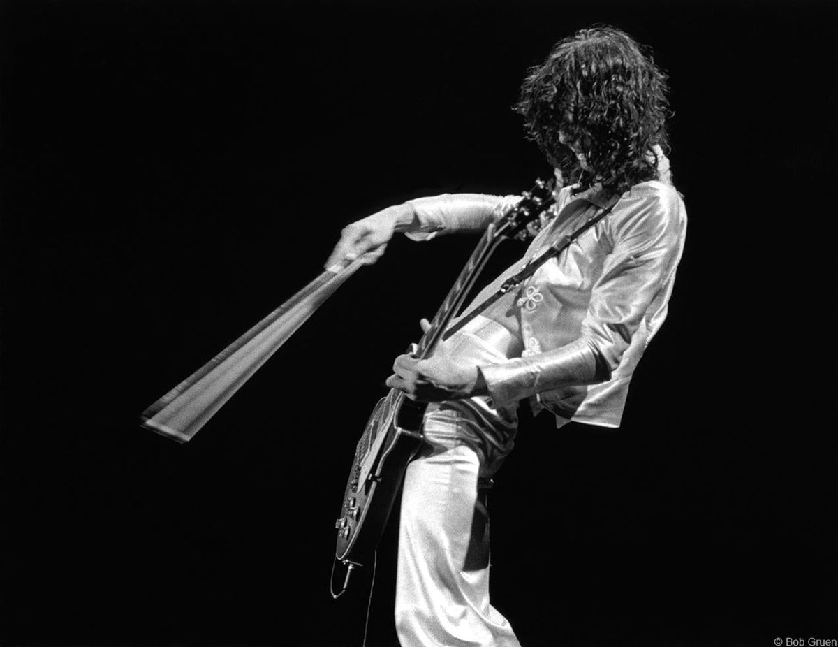 Jimmy Page performing with a guitar bow at Madison Square Garden, New York City, 1977, photographed by Bob Gruen.