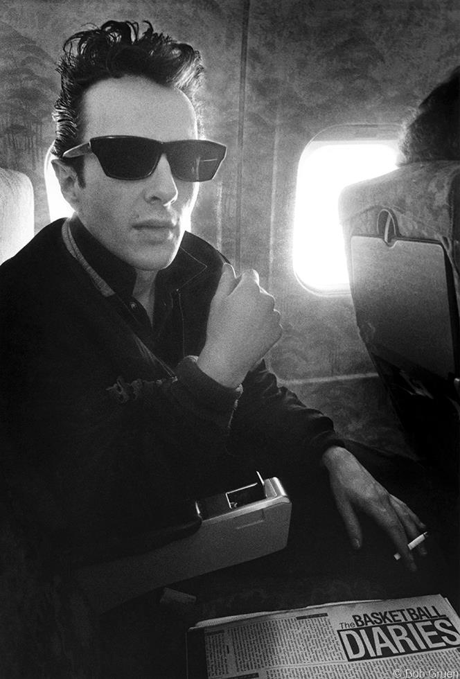 Joe Strummer of The Clash on a plane during the U.S. Tour, 1980, photographed by Bob Gruen.